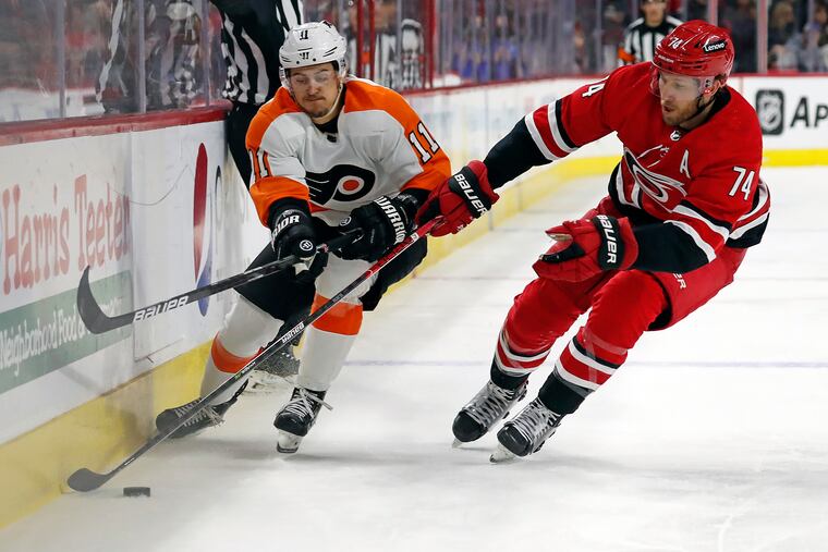 Carolina Hurricanes' Jaccob Slavin (74) separates Philadelphia Flyers' Travis Konecny (11) from the puck during the first period of an NHL hockey game in Raleigh, N.C., Saturday, March 12, 2022. (AP Photo/Karl B DeBlaker)