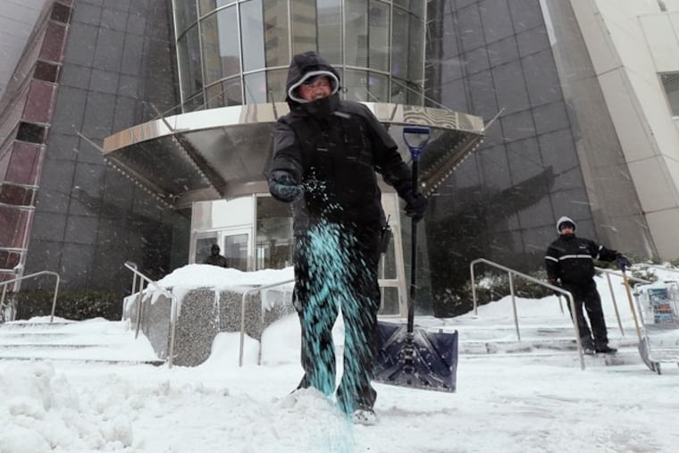 An employee spreads ice melt at a Bally's entrance on in Atlantic City in January.