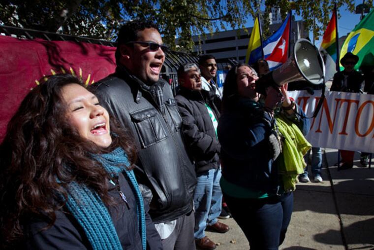 Juntos members (from left) Olivia Vasquez, Miguel Andrade and Erika Almiron during a rally outside immigration offices at North 16th and Callowhill streets on Friday, November 21, 2014.