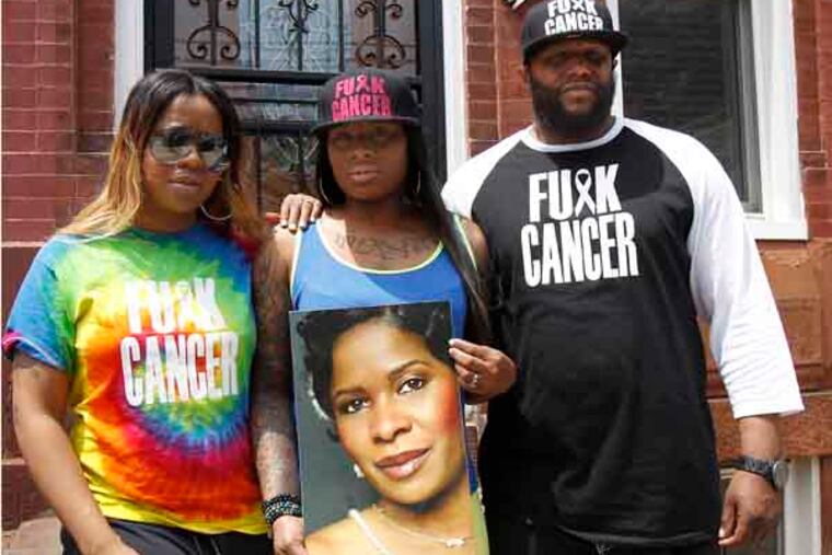Makia Underwood, left, and her sister Zakia Clark, center, along with their uncle Curran Underwood, right, wear their anti-cancer gear in Philadelphia on May 21, 2013. Last Sunday they were escorted from the King of Prussia mall because because they were told the message was offensive. Makia and Zakia's mother recently lost her battle with cancer. Curran was not wearing the cap or shirt when he was in the mall. ( DAVID MAIALETTI / Staff Photographer )