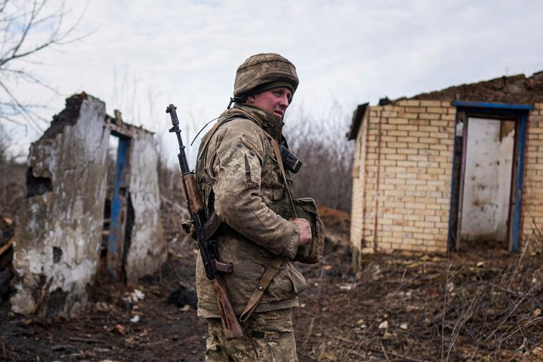 A Ukrainian serviceman stands at his position at the line of separation between Ukraine-held territory and rebel-held territory near Svitlodarsk, eastern Ukraine, Wednesday, Feb. 23, 2022.