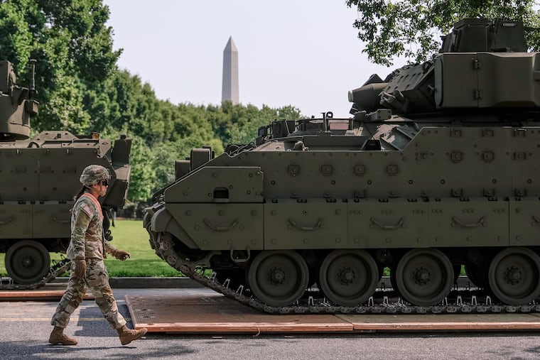 A U.S. Army soldier walks past a Bradley fighting vehicle staged in West Potomac Park on June 11, 2025, in Washington. A new program would allow military veterans to more easily acquire commercial driver's licenses.