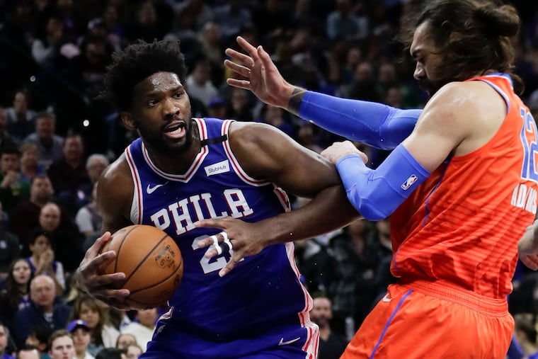 Joel Embiid battles with Thunder center Steven Adams during the second quarter. Tape covers Embiid's dislocated left ring finger.