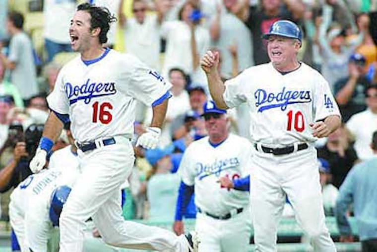 Dodgers' Larry Bowa (right), who spent four years as the Phillies manager, celebrates as Andre Ethier scores a game-winning run over the Phillies back in June. (Associated Press)