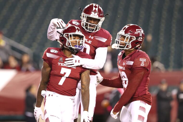 Randle Jones (left) is mobbed by Jose Barbon (center) and Jadan Blue after his first-quarter touchdown catch for Temple against UCF.