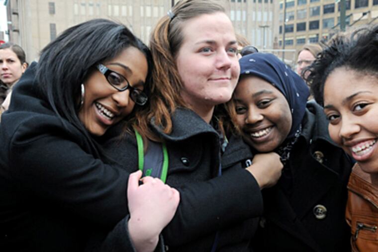 Hope Moffett (center) is hugged by students (from left) Sydney Jackson, Jahneekqua Waiters and Tyneesah Davenport outside school district headquarters yesterday. (Sarah J. Glover / Staff photographer)