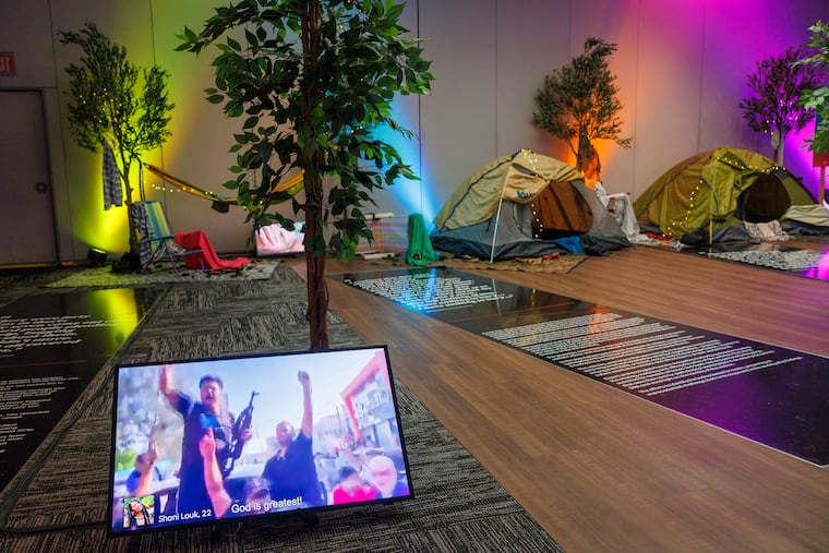A video monitor with recorded footage from the attack is displayed along side tents and other artifacts from the massacre at the Nova Music Festival at The Weitzman on Monday.