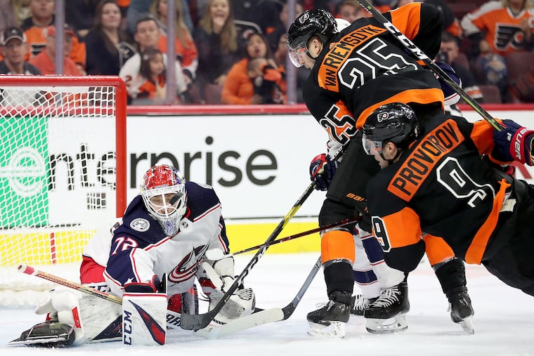 Blue Jackets goaltender Sergei Bobrovsky makes a save with his mask as the Flyers' James van Riemsdyk and Ivan Provorov try to get a rebound in their Dec. 22 meeting. The Flyers dropped a 4-3 decision despite outshooting the Jackets 37-19.