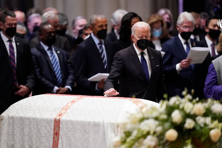 President Joe Biden places his hand on the casket of former Secretary of State Madeleine Albright during the funeral service at the Washington National Cathedral, Wednesday, April 27, 2022, in Washington.