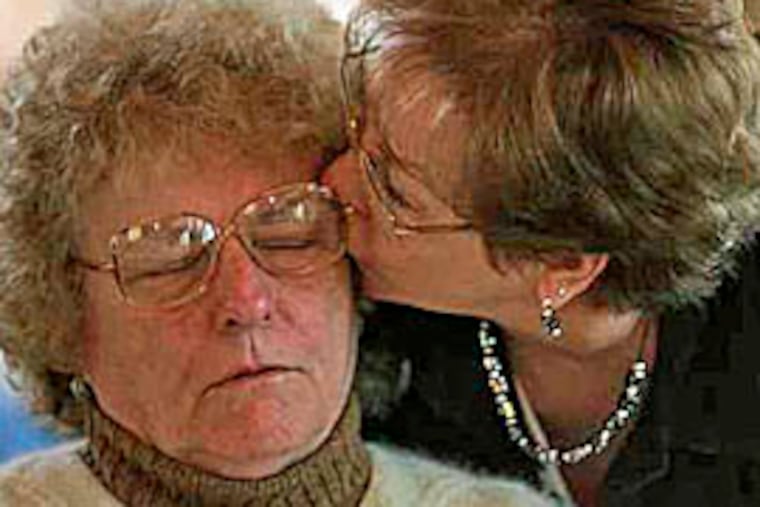 Dorothy Smith, the mother of church shooting victim Rhonda Smith, receives a kiss from Judy Zellner. Police found Rhonda Smith dead inside a Bucks County church. (Michael Perez/Inquirer)