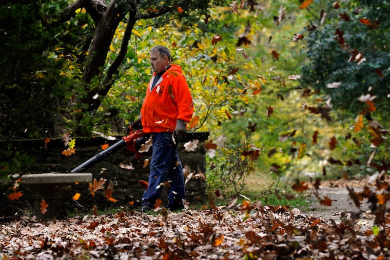 Steve Vasy blows leaves from a terrace next to the Mansion at Ridley Creek State Park.