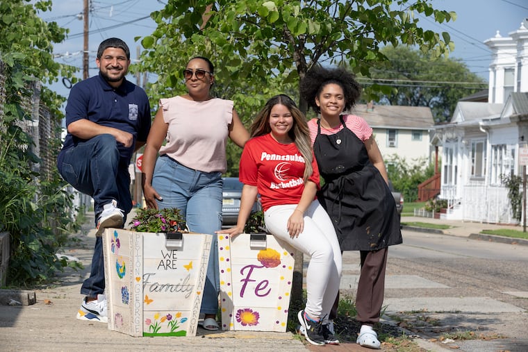 The St. Joseph's Carpenter Society, a non-profit with deep roots in East Camden and Cramer Hill, is helping to cultivate greener neighborhoods through a block-by-block focus partnered with local residents. L-R: Felix Moulier of the St. Joseph's Carpenter Society, resident Ruth Perez, artistic director Estefany Rodriguez, and Lisnette Peña with the flower boxes on the 2700 block of Arthur St. in Camden, N.J. on July 27, 2023.