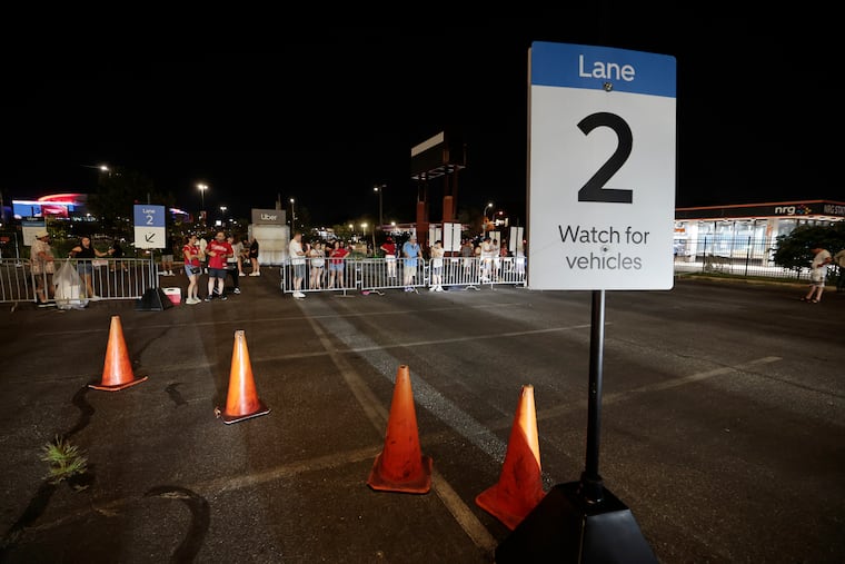 Baseball fans attempt to get Ubers in Lot T after a Mets vs. Phillies game at Citizens Bank Park earlier this month. Drivers say the situation is a microcosm of larger issues, including decreased pay.