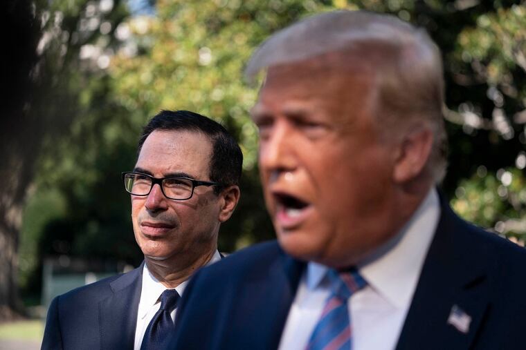 Secretary of the Treasury Steven Mnuchin listens as U.S. President Donald Trump speaks to the press outside the White House in Washington, D.C.