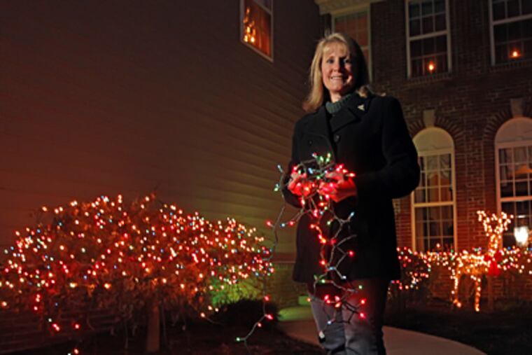 After notification from the Doylestown Station condo association board that her white-lighted reindeer was in violation, resident Judith Wonderly went all out and strung colored lights outside her home. (Michael Bryant / Staff Photographer)
