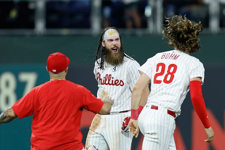 Brandon Marsh celebrates his game-winning RBI single in the 11th inning with teammates Alec Bohm and Rafael Marchán.