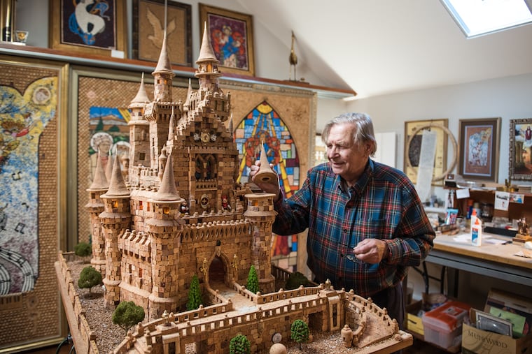 Huntingdon Valley's Walter Deuschle inspects his 40-inch-high, 56-inch-wide replica of Disney World’s Cinderella Castle, constructed from 7,300 corks.
