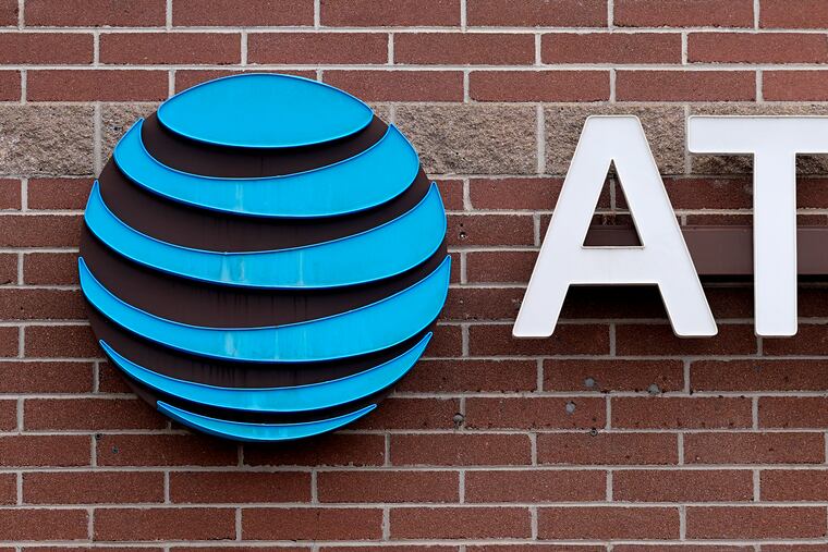 The company logo hangs over the door to an AT&T store in Denver. AT&T says it will give affected customers $5 each to compensate for last week's cellphone network outage that left many without service for hours.