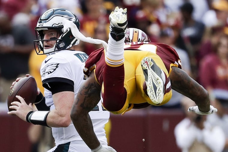 Eagles quarterback Carson Wentz eludes Washington Redskins inside linebacker Mason Foster during the third-quarter on Sunday.