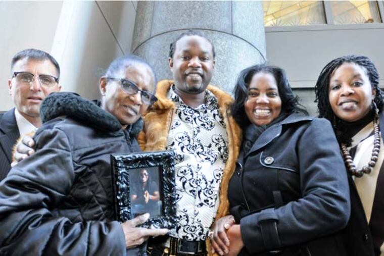 From left Dective George Pirrone, Hortencia Jarvis, holding a photo of her late son Gregory Jarvis, his brother Andres Jarvis who solved the case, and his sisters Jacquelyn Connor-Joseph, and Lorelley Jarvis stand outside the Criminal Justice Center after the sentencing of Gregory's killer Shamsaddin Sallam. ( RON TARVER / Staff Photography )