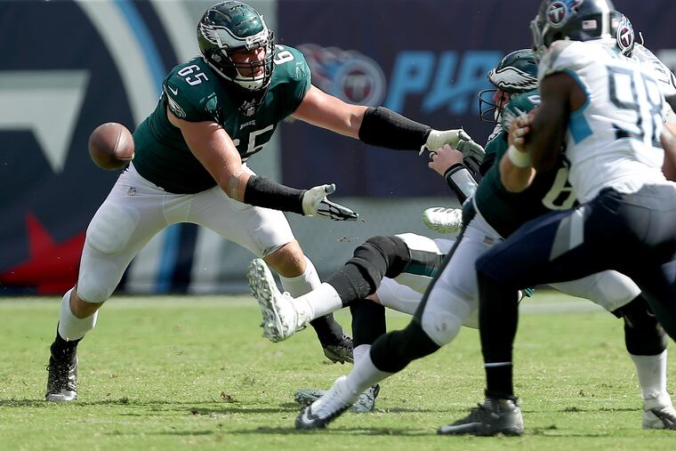 Eagles' Lane Johnson, left, tries to help Carson Wentz, right, after Wentz fumbled the ball against the Titans. The Philadelphia Eagles lose 26-23 in overtime to the Tennessee Titans in Nashville, TN on September 30, 2018. DAVID MAIALETTI / Staff Photographer