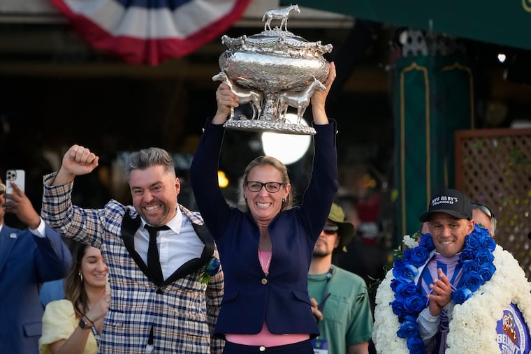 Trainer Jena Antonucci (center) hoists up the August Belmont Trophy alongside jockey Javier Castellano (right) and owner Jon Ebbert. She was the 11th woman to have a horse compete at the Belmont Stakes and first to win.