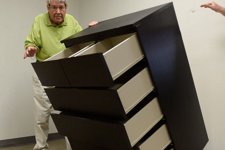 Bobby Puett, president of Diversified Testing Labs, watches as the Ikea Malm six drawer dresser falls over during a tip over test at Diversified Testing Labs in Burlington, North Carolina, (Sara D. Davis/For the Inquirer)