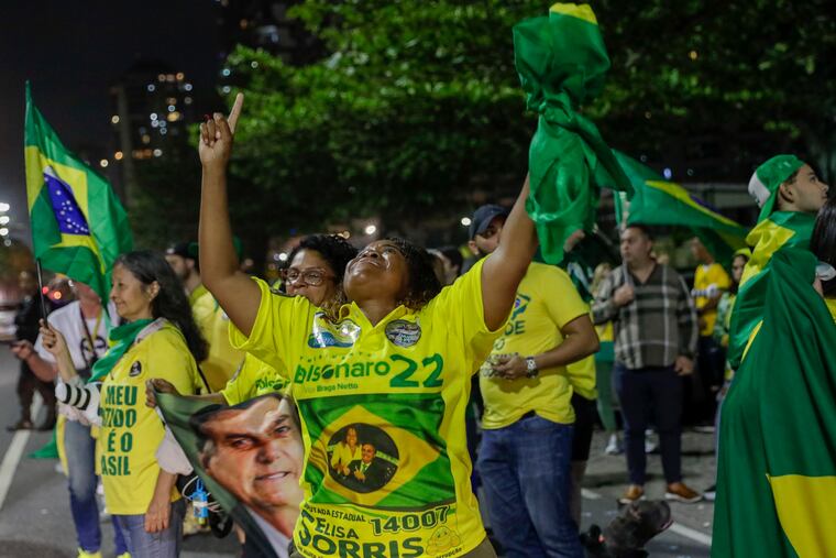 Supporters of Brazilian President Jair Bolsonaro celebrate partial results after general election polls closed outside his family home in Rio de Janeiro.
