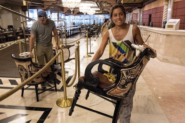Kira Wong of Hoboken, NJ with chair at the Taj Mahal liquidation sale in Atlantic City on Thursday. In background is boyfriend Mike Kuhn.