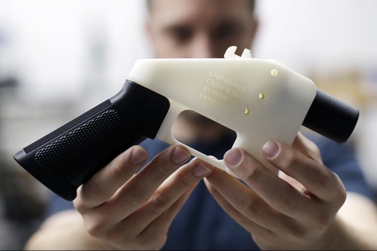 FILE – In this Aug. 1, 2018, file photo, Cody Wilson, with Defense Distributed, holds a 3D-printed gun called the Liberator at his shop in Austin, Texas.