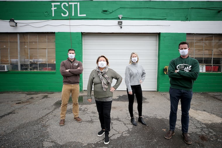 Marie Siravo (second from left), owner of Four Seasons Total Landscaping, poses for a portrait with her son, Michael (left), her daughter-in-law, Melissa, (second from right) and Sean Middleton (right), outside their office. The landscaping business is dealing with their sudden fame after Rudy Giuliani's press conference.