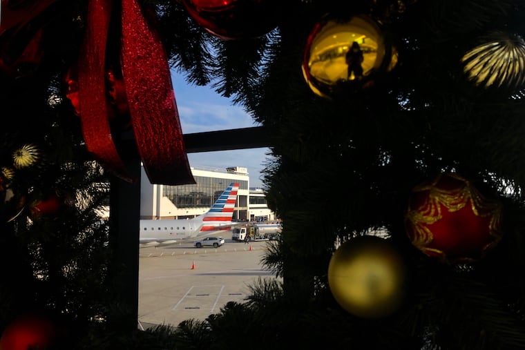 A Christmas wreath frames a plane at Philadelphia International Airport on Wednesday, Nov. 25, 2020. Even during this unusual holiday season, writes Solomon Jones, Americans should remember what we have in common.