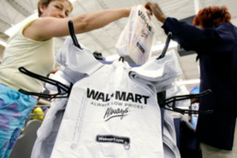 A Wal-Mart customer takes her purchases after checking out at a store in Niles, Ill. Heavy back-to-school shopping last month helped retailers rebound from a slow July. Still, mortgage defaults and a volatile stock market could affect holiday shopping.