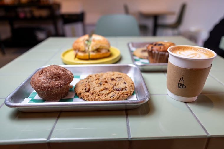 Various baked goods from Little Bean, the new coffee shop from the team behind Cleo Bagels. From left to right: the Applething, an oatmeal cranberry cookie, vanilla cappuccino, blueberry muffin, chocolate chip cookie, and Ramen Thing bagel sandwich.