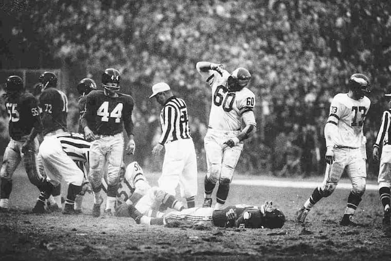 Eagles' Chuck Bednarik stands over Giants' Frank Gifford.