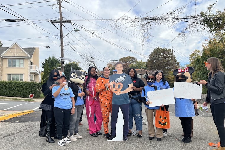 Members of Make the Road Action New Jersey and Pennsylvania and the Working Families party gather around a cutout of Mehmet Oz. On Halloween, the group went 'Trick or Treating' in Cliffside Park, N.J., where Oz lived for more than 20 years.