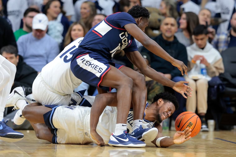 Hassan Diarra of UConn and TJ Bamba of Villanova go after a loose ball during the second half Saturday at the Wells Fargo Center.