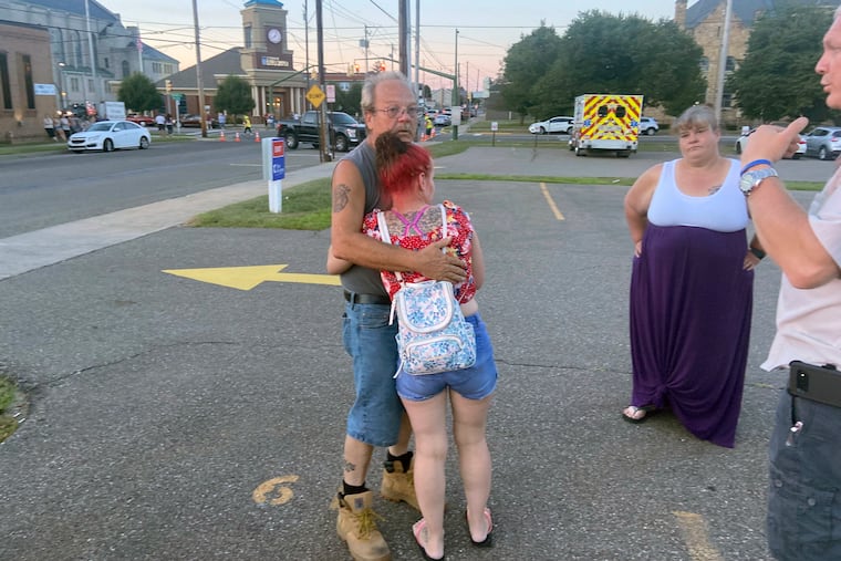 Nescopeck Volunteer Fire Company firefighter Harold Baker is comforted at the scene in Berwick, Pa., on Saturday after authorities said a vehicle struck a crowd gathered at a bar to raise money for victims of a house fire that killed 10 earlier in the month.