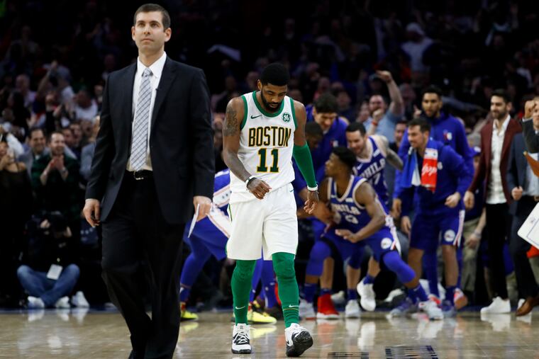Boston Celtics' Kyrie Irving, center, and coach Brad Stevens, left, walk the court for a timeout after Jimmy Butler scored a basket during the second half of an NBA basketball game on March 20 in Philadelphia. The Celtics lost 115-118.