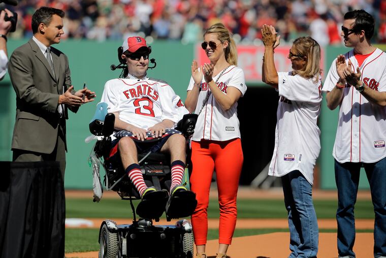 FILE - In this April 13, 2015, file photo, Pete Frates, former Boston College baseball player whose Ice Bucket Challenge raised millions for ALS research, is applauded by Boston Red Sox general manager Ben Cherington, far left, and his wife Julie Frates, center, along with other family members prior to the home opener baseball game between the Boston Red Sox and the Washington Nationals at Fenway Park in Boston. Frates, who was stricken with amyotrophic lateral sclerosis, or ALS, died Monday, Dec. 9, 2019. He was 34.