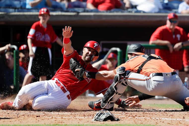 Orioles catcher Austin Wynns tags out Phillies Lane Adams at home plate.