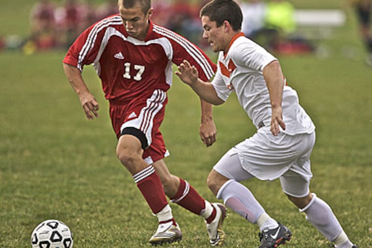 Cherry Hill East's Brian Reynolds and Cherokee's Kyle Kopervas fight for the ball. (John Costello / Staff Photographer)