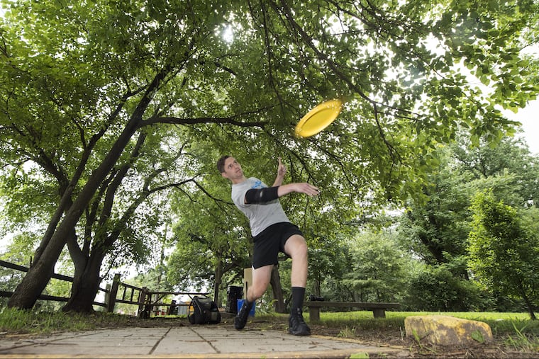 Alex Caldwell, throws a flying disc at the Sedgley Woods' 27-hole disc golf course in East Fairmount Park.