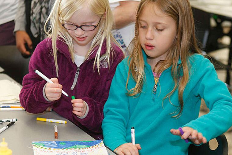 Grace Stark and Arielle Biran, both 8, at Gladwyne Elementary School, paint a Dream Flag, (Akira Suwa/Staff)