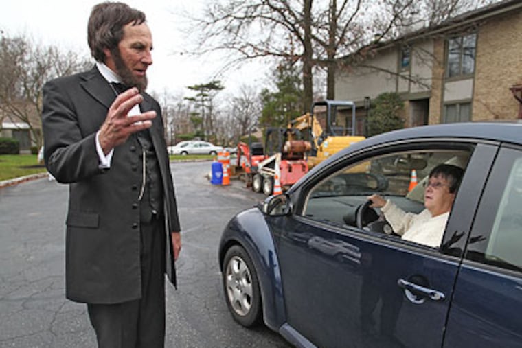 Christian Johnson, reenacting Abraham Lincoln, chats with a neighbor, Chris Hughes, outside of his home in Cherry Hill. Hughes, familiar with Johnson's career as an historic reenactor, stopped while driving home and greeted him with "Hello, Mr. President." (David M Warren / Staff Photographer)