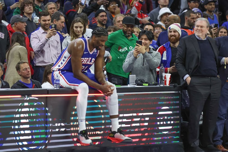 Fans look on while Joel Embiid sits on the scorer’s table during the Sixers' win against the Oklahoma City Thunder.