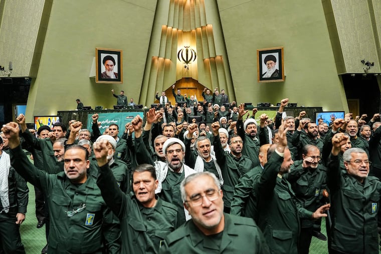 In this handout photo released by the Islamic Consultative Assembly News Agency (ICANA) Iranian lawmakers chant slogans as they wear the Revolutionary Guard's uniform in a session of parliament, in Tehran, Iran, Sunday, Feb. 1, 2026.