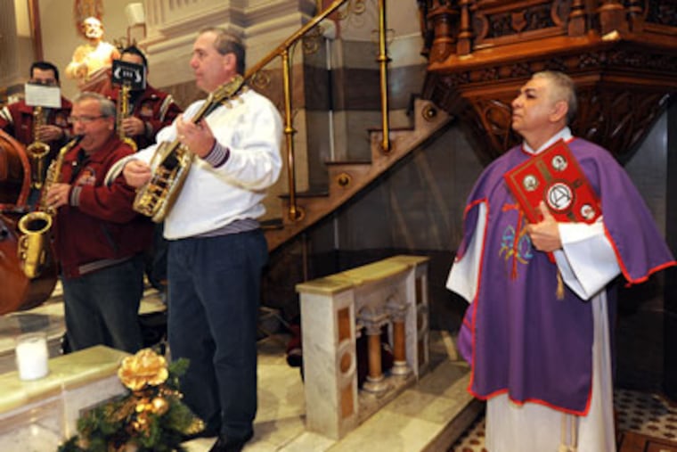 PMUMMERS19P8 In Philadelphia, the 29th annual Mummers Mass at St. Peters Church at 5th and Girard, plus the Polish-American String Band practicing at Front and Mifflin. Here, at the church, members of the Quaker City String Band play; at right is Deacon Juan Ramos 12/18/11 APRIL SAUL / Staff Photographer
