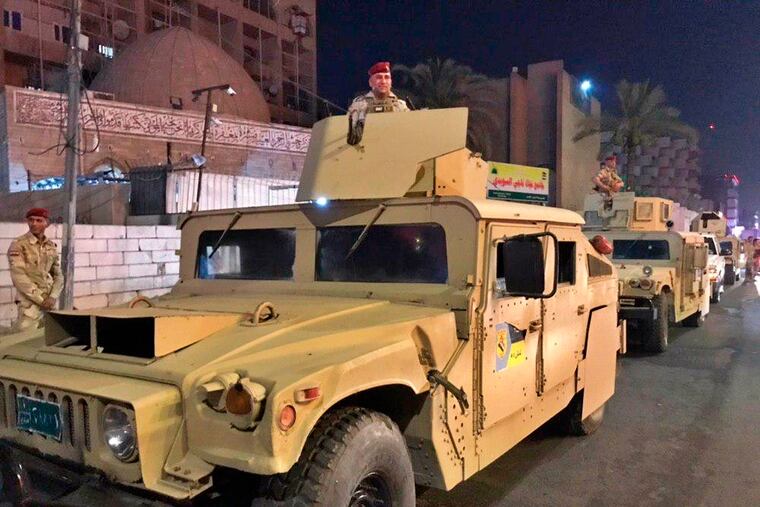 Iraqi security forces stand guard near Bahraini embassy in Baghdad, Iraq, Thursday, June 27, 2019. Protesters stormed the Bahraini embassy compound in Baghdad Thursday night, removing the flag from above the building and replacing it with a Palestinian banner in protest against a conference held in the gulf nation to promote peace between Arabs and Israelis. (AP Photo/Ali Abdul Hassan)