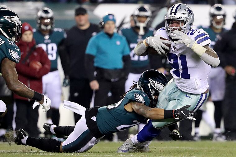 Cowboys running back Ezekiel Elliott trying to run through the arms of Eagles defender Avonte Maddox last December.